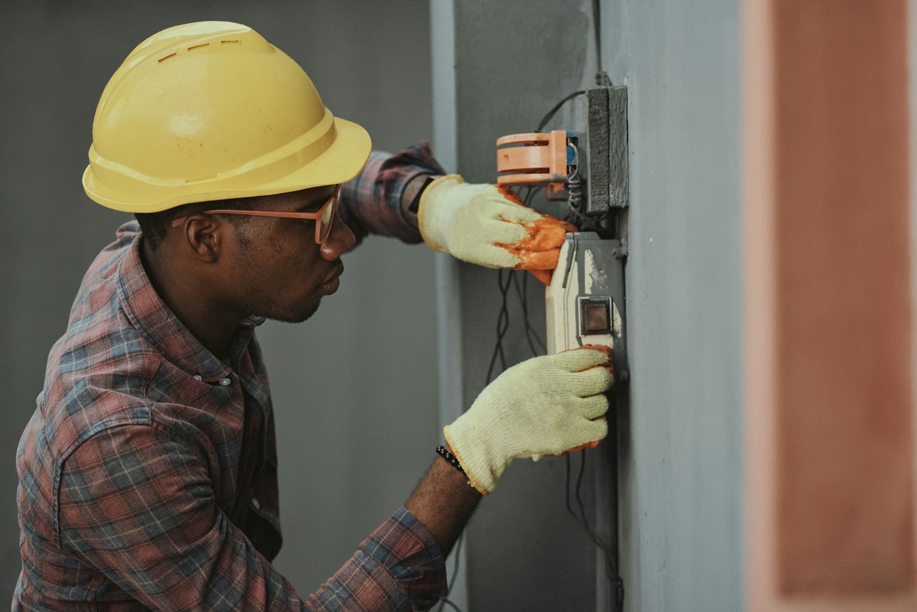 Electrician in a yellow hard hat installing wiring